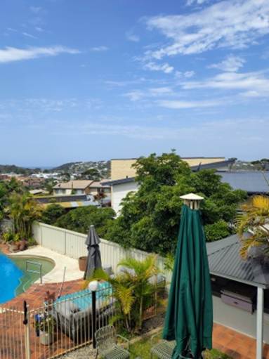 A view of a pool and a building from a balcony

AI-generated content may be incorrect.